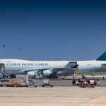 Avião cargueiro sendo carregado no pátio de um aeroporto.