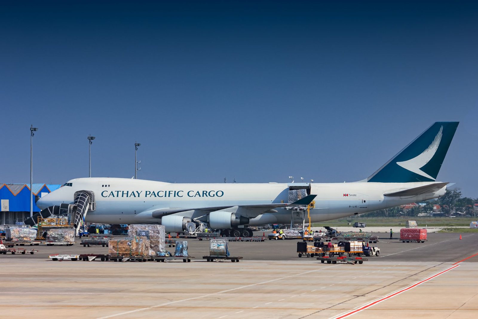 Avião cargueiro sendo carregado no pátio de um aeroporto.