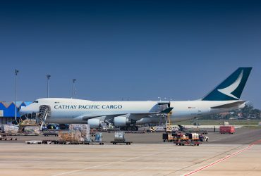 Avião cargueiro sendo carregado no pátio de um aeroporto.