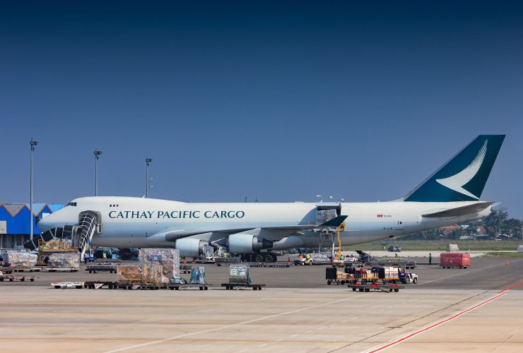 Avião cargueiro sendo carregado no pátio de um aeroporto.