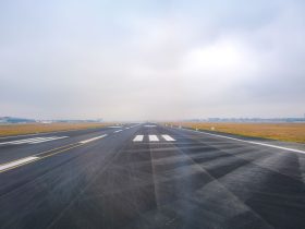 Vista longitudinal de uma pista de aeroporto vazia em um dia de pouca visibilidade.