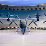 Protótipo futurista de aeronave elétrica com hélices exposto em ambiente interno.