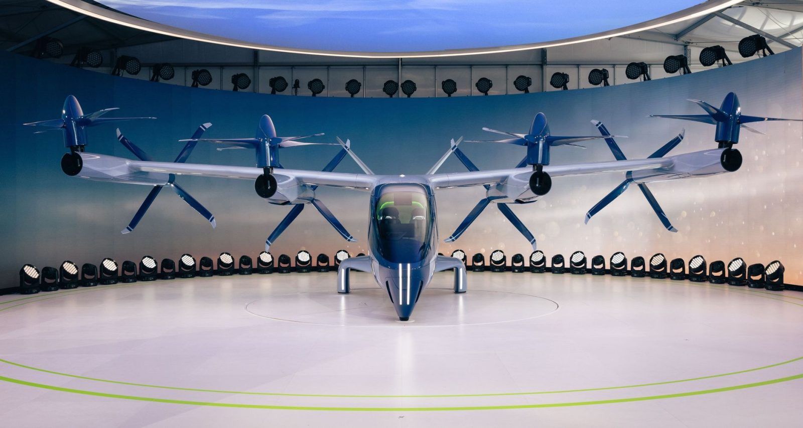 Protótipo futurista de aeronave elétrica com hélices exposto em ambiente interno.