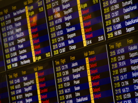 Painel digital de um aeroporto exibe informações sobre chegadas e partidas de voos.