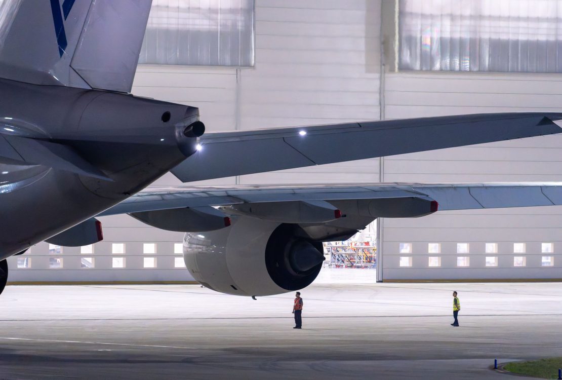 Equipe de manutenção inspeciona uma aeronave dentro de um hangar