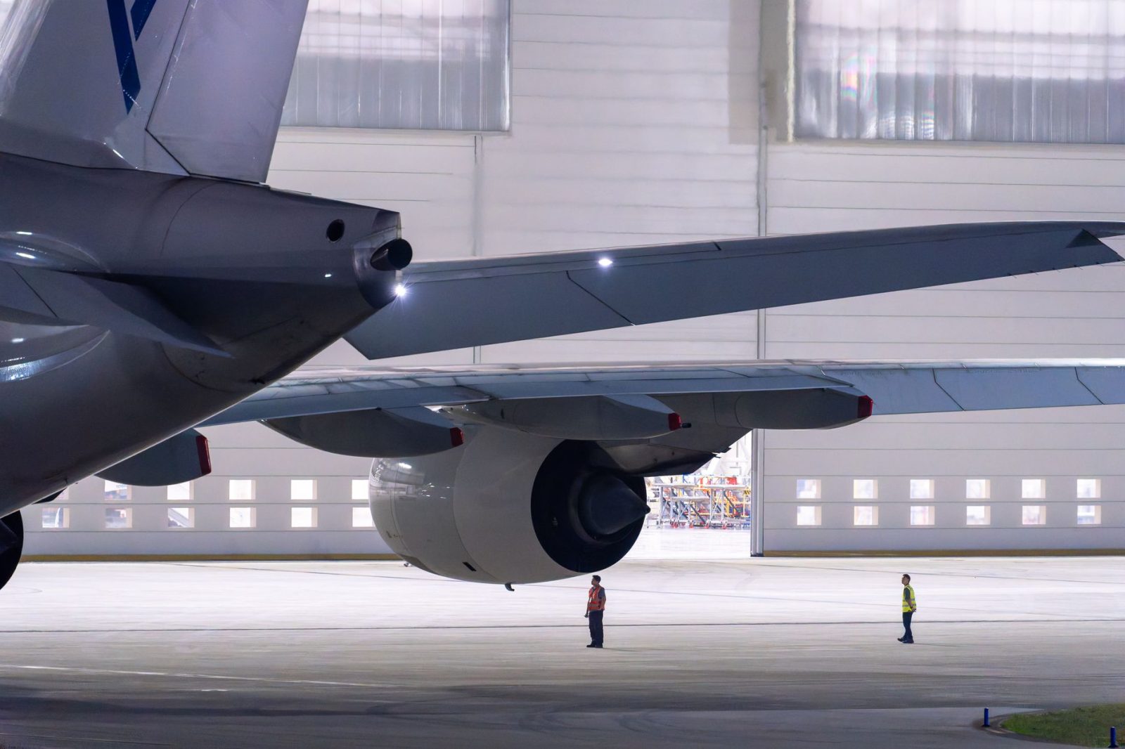 Equipe de manutenção inspeciona uma aeronave dentro de um hangar