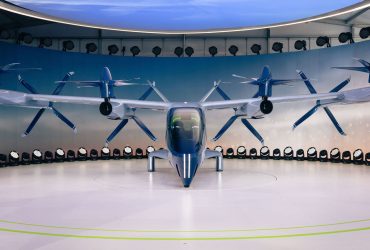 Protótipo futurista de aeronave elétrica com hélices exposto em ambiente interno.