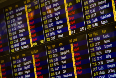 Painel digital de um aeroporto exibe informações sobre chegadas e partidas de voos.