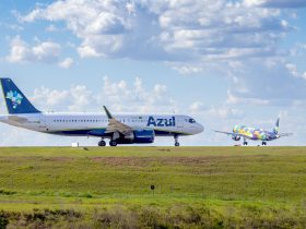 Aeronaves da Azul estacionadas ou em operação na pista de um aeroporto sob céu azul.