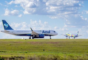 Aeronaves da Azul estacionadas ou em operação na pista de um aeroporto sob céu azul.