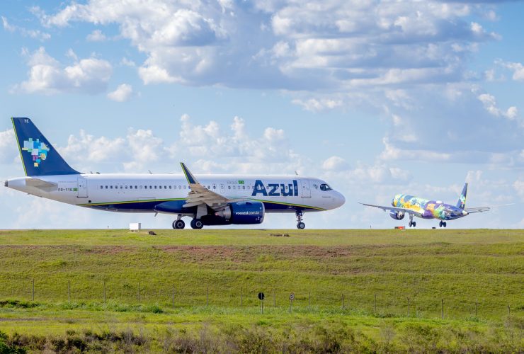 Aeronaves da Azul estacionadas ou em operação na pista de um aeroporto sob céu azul.