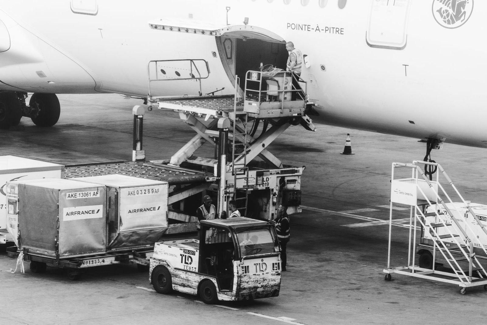 Carga sendo embarcada em um avião no pátio de um aeroporto.