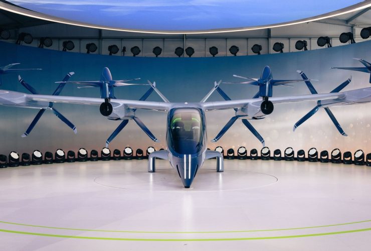 Protótipo futurista de aeronave elétrica com hélices exposto em ambiente interno.