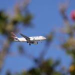 Avião comercial da LATAM voando sob céu azul sobre Florianópolis, no Brasil.