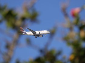 Avião comercial da LATAM voando sob céu azul sobre Florianópolis, no Brasil.