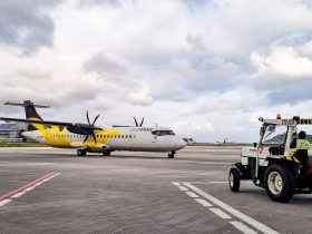 Aeronave turboélice na pista de um aeroporto no Rio de Janeiro, com equipe de solo auxiliando a operação.
