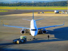 Avião comercial se prepara para decolar em um aeroporto de Minas Gerais, em dia claro.