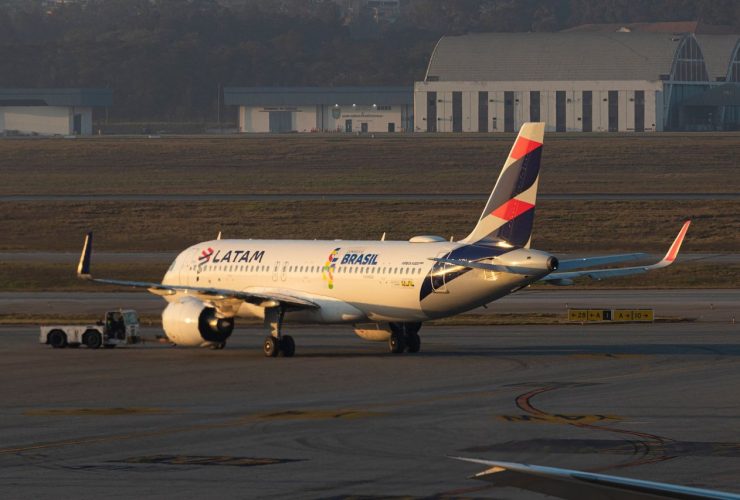 Aeronave da LATAM na pista de um aeroporto de São Paulo durante o amanhecer