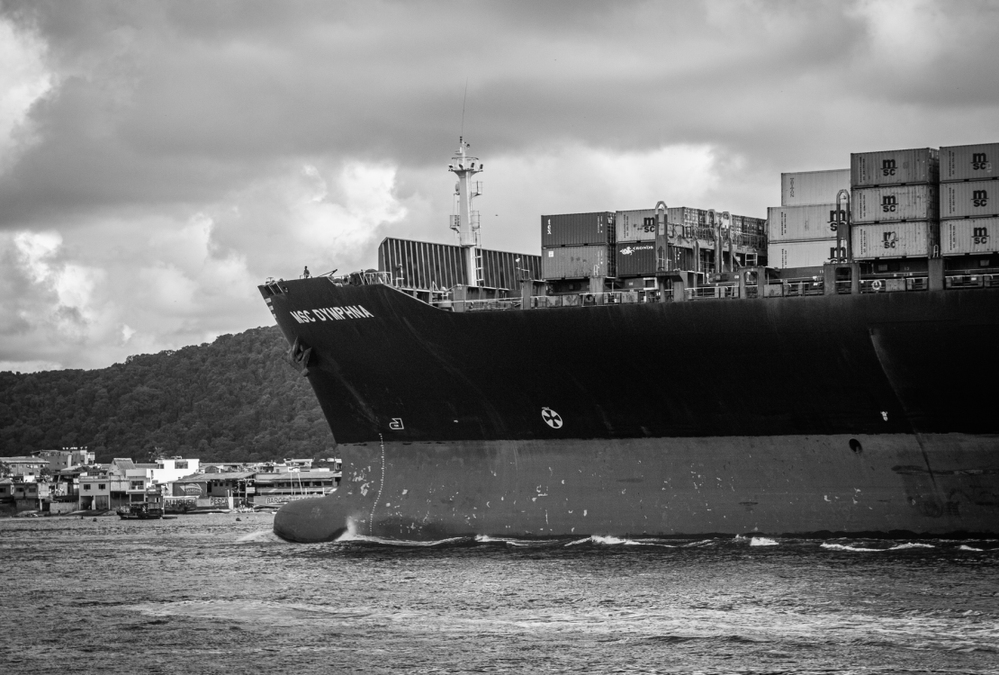 Navio porta-contêineres atracado no Porto de Santos, em imagem em preto e branco.