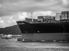 Navio porta-contêineres atracado no Porto de Santos, em imagem em preto e branco.