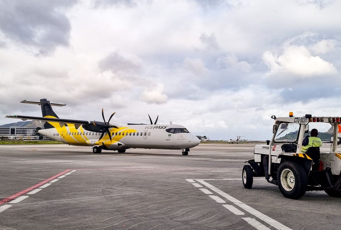 Avião turboélice na pista de um aeroporto no Rio de Janeiro, acompanhado por equipe de solo.