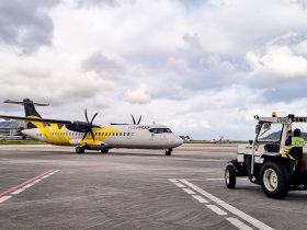Avião turboélice na pista de um aeroporto no Rio de Janeiro, acompanhado por equipe de solo.