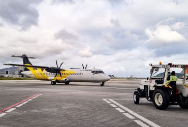 Avião turboélice na pista de um aeroporto no Rio de Janeiro, acompanhado por equipe de solo.